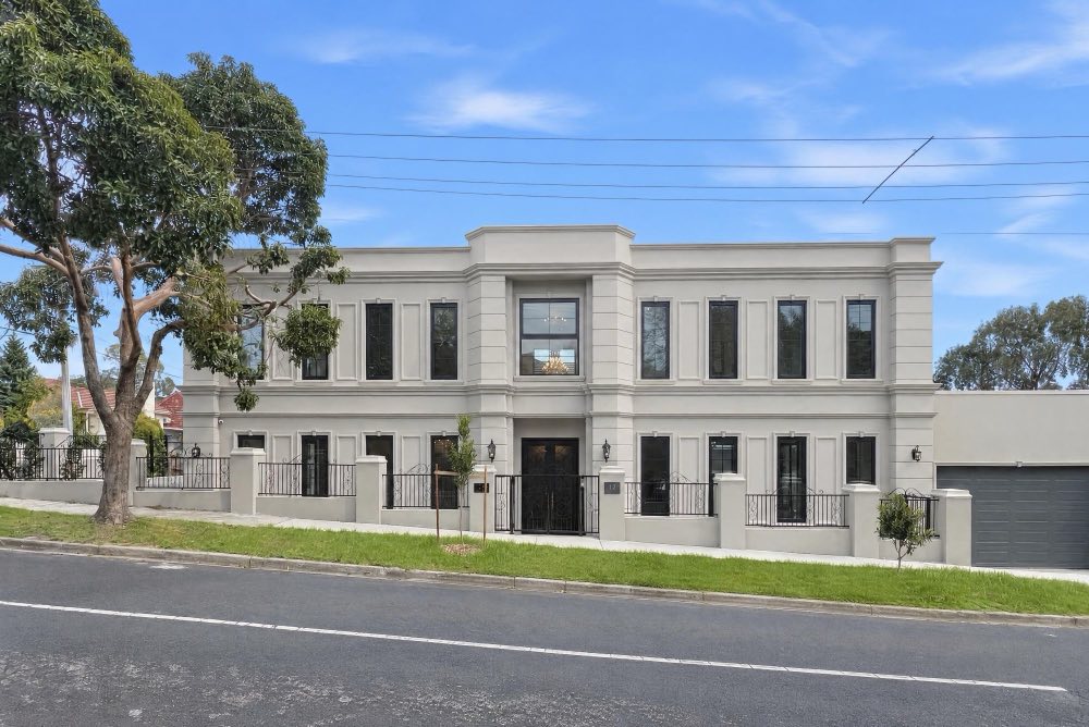 A two storey rendered house behind a big gum tree. A crop frame closes in to trim the road and the sky, then the photo zooms to the cropped result