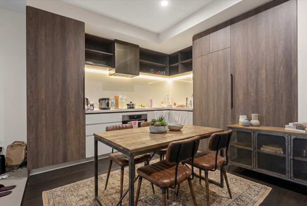 Kitchen and dining before decluttering — appliances, bottles and bags across the bench and floor