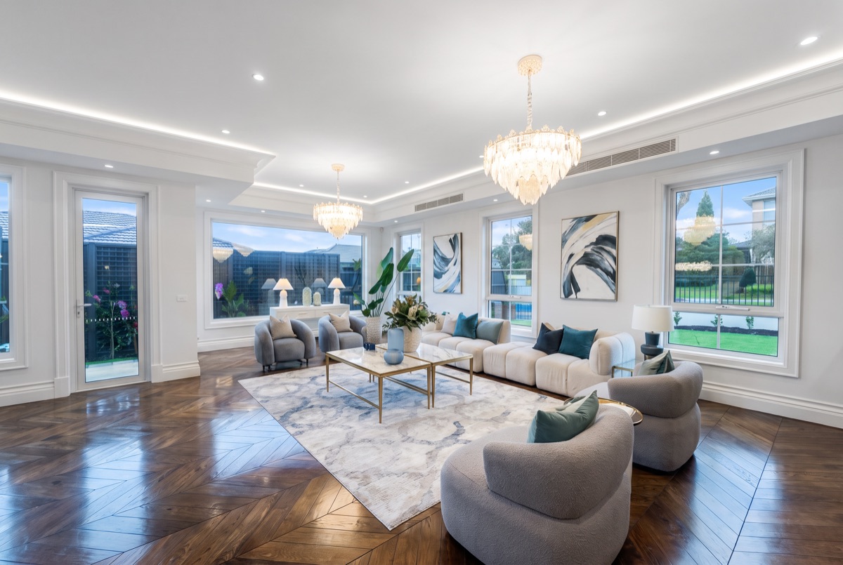 A formal living room finished in Bright & White: true white walls and ceiling, clean daylight colour, the garden held through every window.