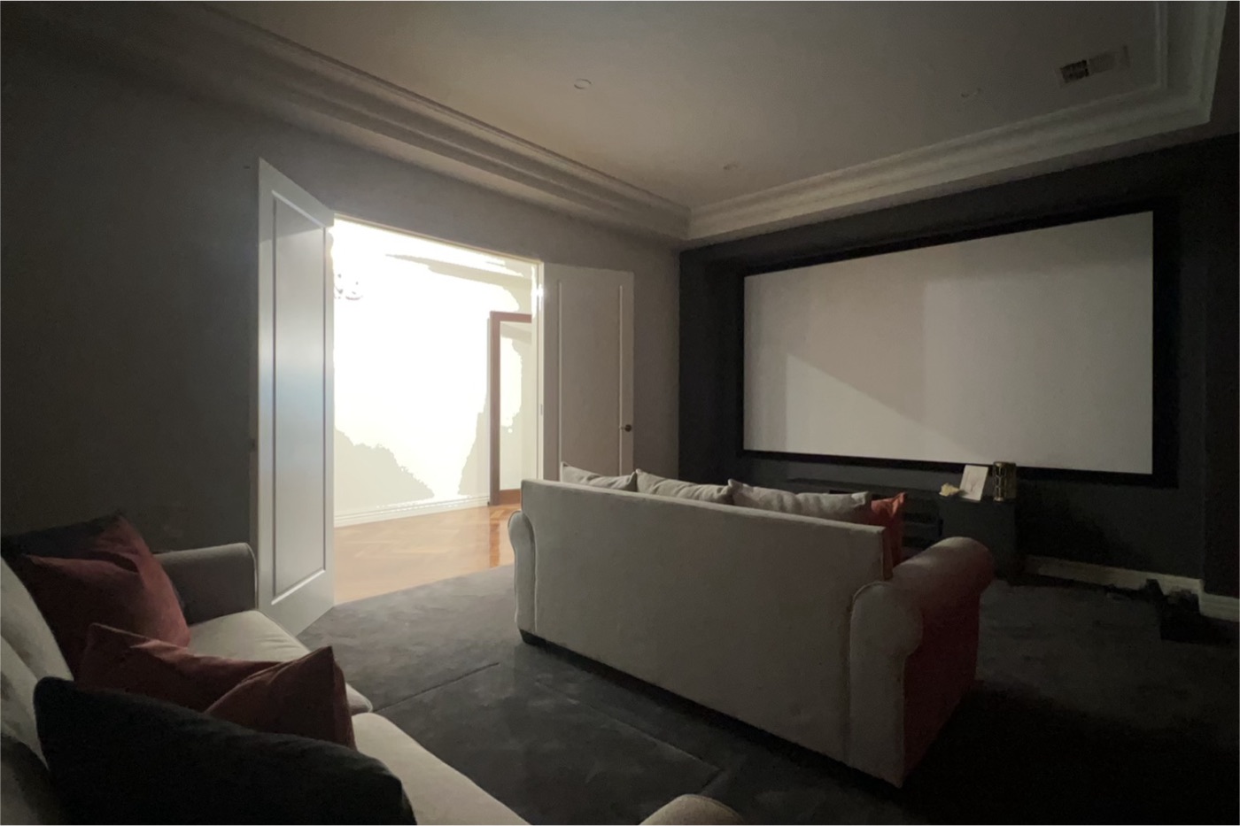 Live capture view — a dim home-theatre room straight off the phone, doorway blown out